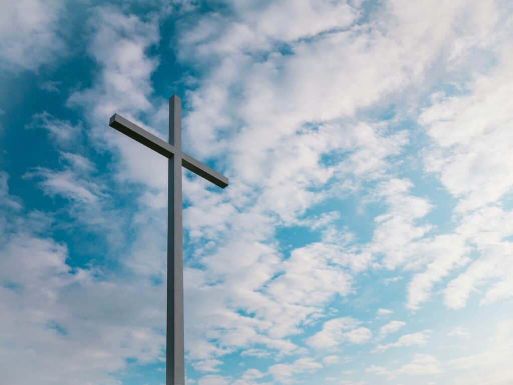 '' wooden cross against a blue sky with white clouds representing walking in the Spirit''
