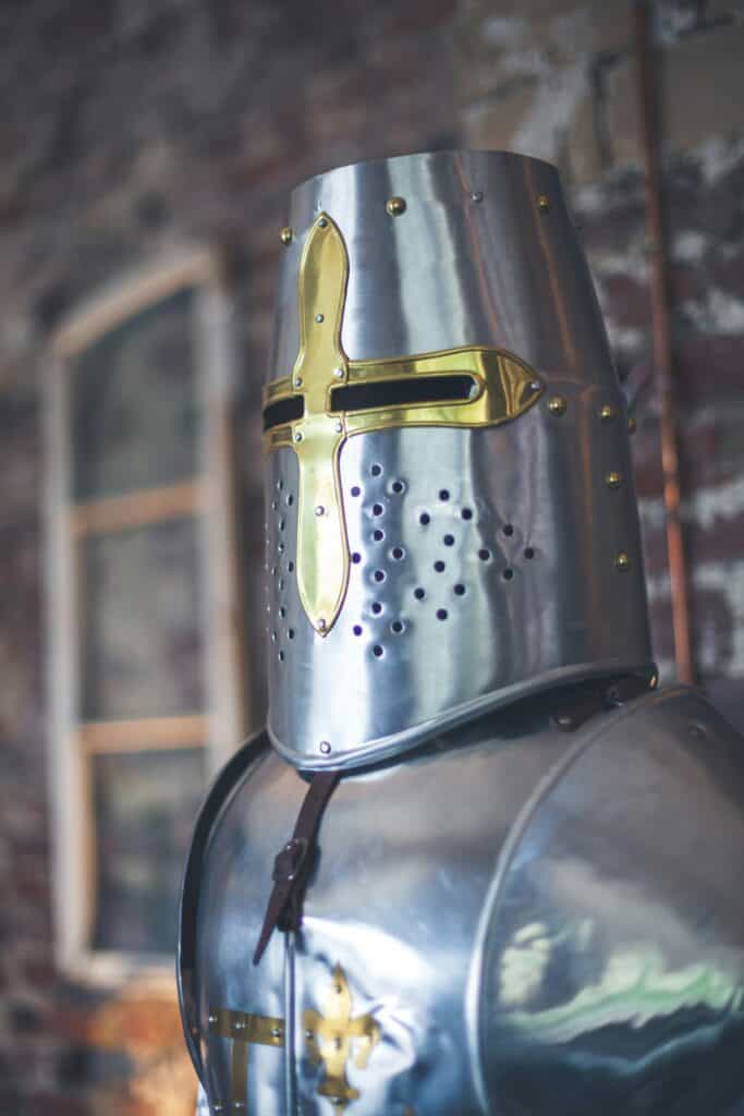 Medieval knight's helmet with polished steel and gold accents representing the Helmet of Salvation from the biblical Armor of God