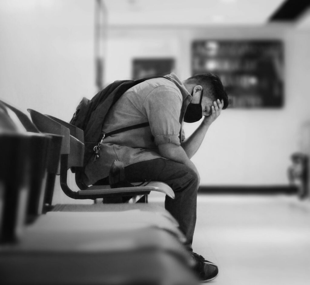 Black and white photo of a person sitting on a chair with head in hands in a contemplative pose, suggesting that conviction is part of walking in the Spirit