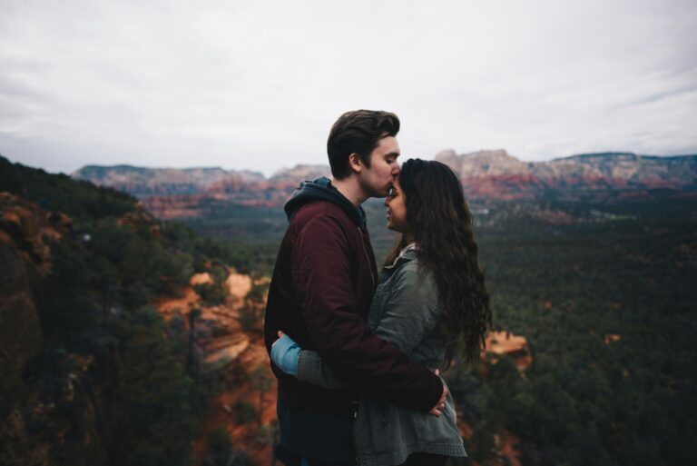 A couple embracing outdoors with mountains in the background, symbolizing love, commitment, and the strength of God-centered relationships inspired by Bible verses about relationships.