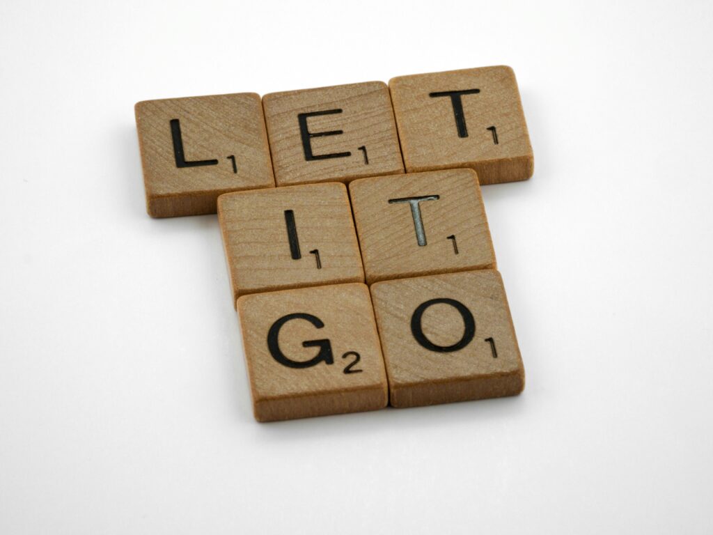 "Scrabble-style wooden tiles arranged to spell 'Let It Go' illustrating the biblical practice of releasing anxiety to God through prayer and trust"